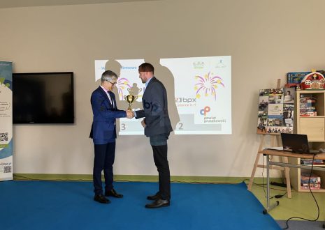 Prezes wręcza puchar mężczyźnie.