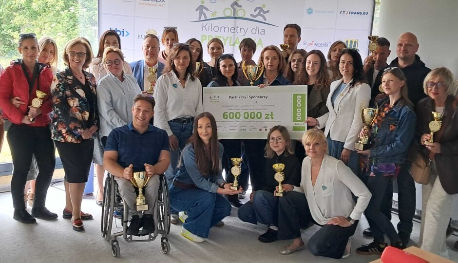 Przedstawiciele firm wspierających akcję pozują z pucharami i czekiem na 600 tysięcy złotych.