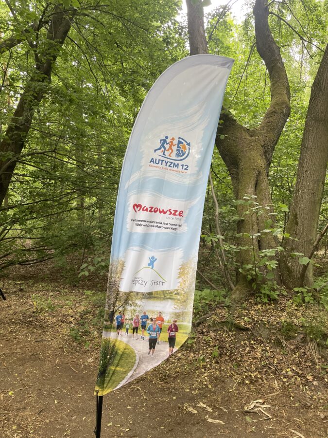 Wind flaga z logo Autyzmu 12, Mazowsza i Fundacji Lepszy Start.